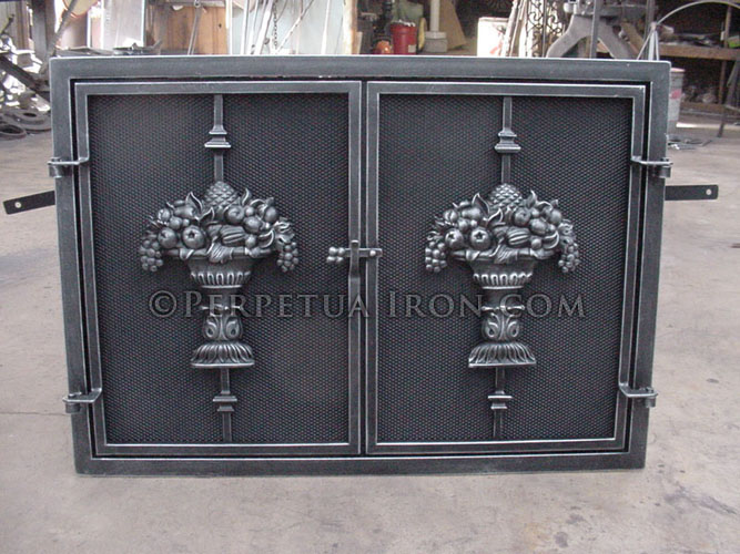 Rectangular two door fireplace screen with Grecian Urn design centered on solid steel fire screen doors. Natural steel patina.