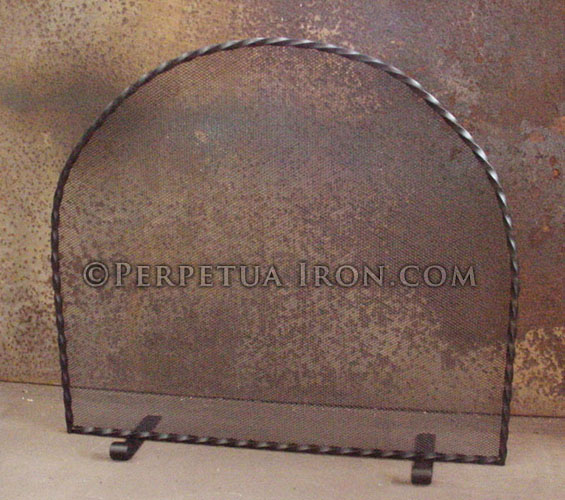 Simple curve topped wrought iron fireplace screen with twisted square stock frame and steel mesh with bronze patina.