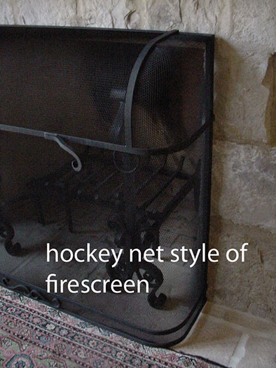 This black steel mesh screen resembles a hockey net in that it bulges out beyond the fireplace surround.  The screen is reinforced by steel bands.