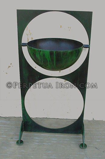 A dark green decorative iron plant stand with swinging bowl.