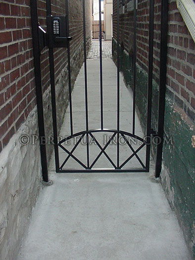detail of 19.4, ornamental iron gate in narrow brick pathway