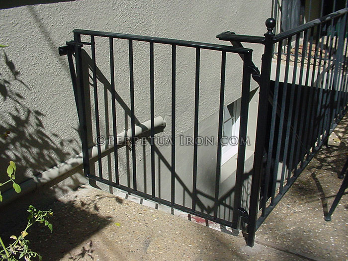 black iron simple safety gate for outdoor basement entry.