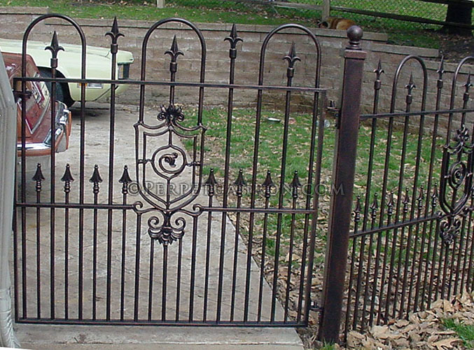 Decorative iron gate for a garden with alternating hoop top and spear point pickets, and dual outline sheild motif in center