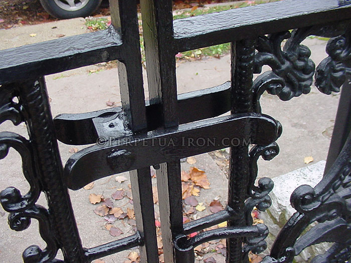 Close up view of a simple lever latch on an iron gate.