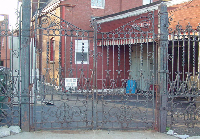 Massive gate to a courtyard for an old cultural organization double gate with green and rust patina.