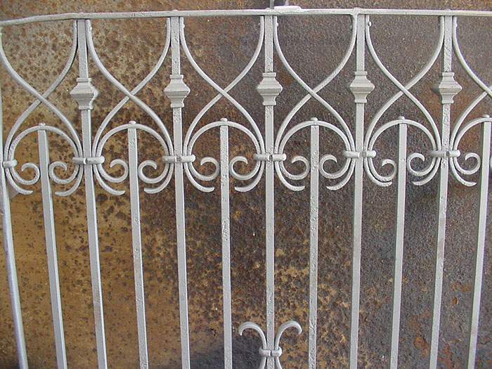 interlocking scroll work on antique white railing.