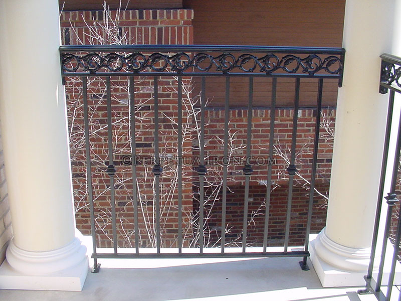 Wrought iron rail for an upper story porch, design includes nodes and circle vine casting.