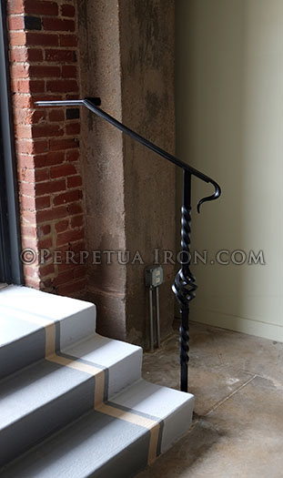 Interior iron handrail with twisted iron and basket form.