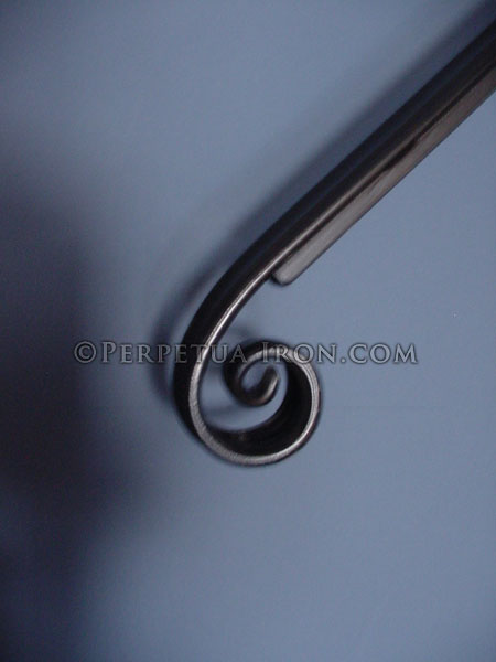 Close up detail of a hand forged coil end design hand rail end.
